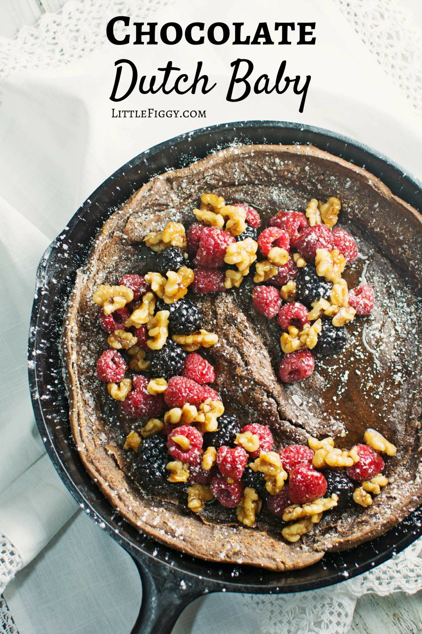 Enjoy a decadent breakfast or dessert with this Chocolate Dutch Baby served with fresh fruit and drizzles of warmed maple syrup and toasted walnuts! Recipe @LittleFiggyFood