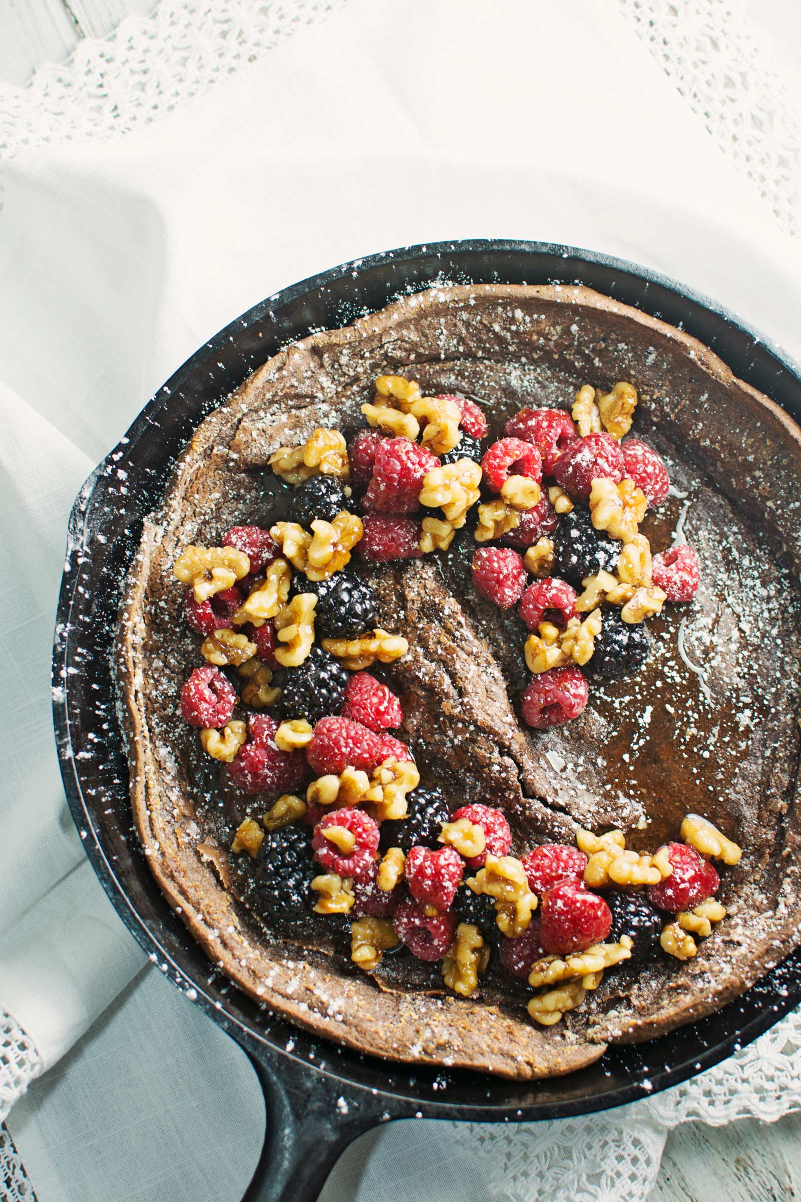 Enjoy a decadent breakfast or dessert with this Chocolate Dutch Baby served with fresh fruit and drizzles of warmed maple syrup and toasted walnuts! Recipe @LittleFiggyFood