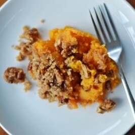 Sweet potato casserole on white plate with fork.