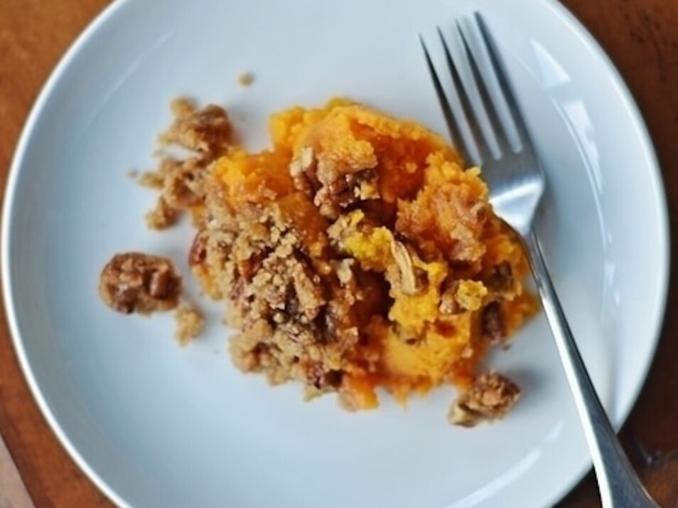 Sweet potato casserole on white plate with fork.