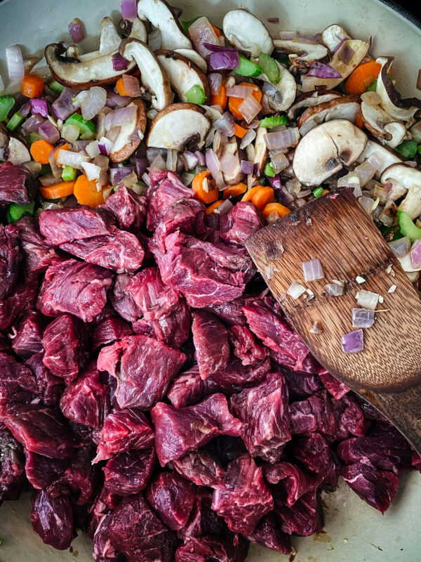 Adding in the stewing beef to the stew