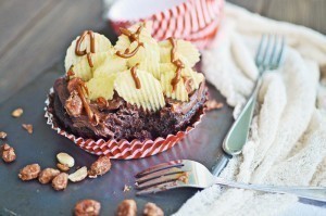 Chocolate Buttermilk Cupcakes topped with ridged potato chips and drizzled with chocolate, placed in a red-striped cupcake liner on a slate board with forks, peanuts, and a light napkin nearby.