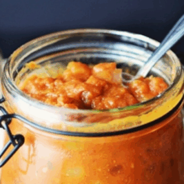 Jar of homemade pumpkin chutney with a spoon.