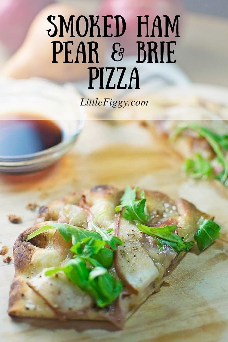 A slice of Smoked Ham Pear and Brie Pizza garnished with fresh greens sits on a wooden board, accompanied by a small bowl of sauce and another pizza slice in the background. Text on the image reads Smoked Ham Pear & Brie Pizza.