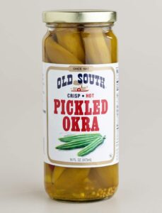 A jar of Old South Crisp Hot Pickled Okra, 16 fl. oz. The clear jar shows whole pickled okra pods and spices inside, with a white label and red and blue text on the front.