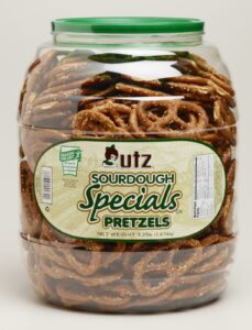 A large clear plastic jar filled with Utz Sourdough Specials Pretzels, featuring a green lid and a white label with green and gold accents displaying the brand and product name.