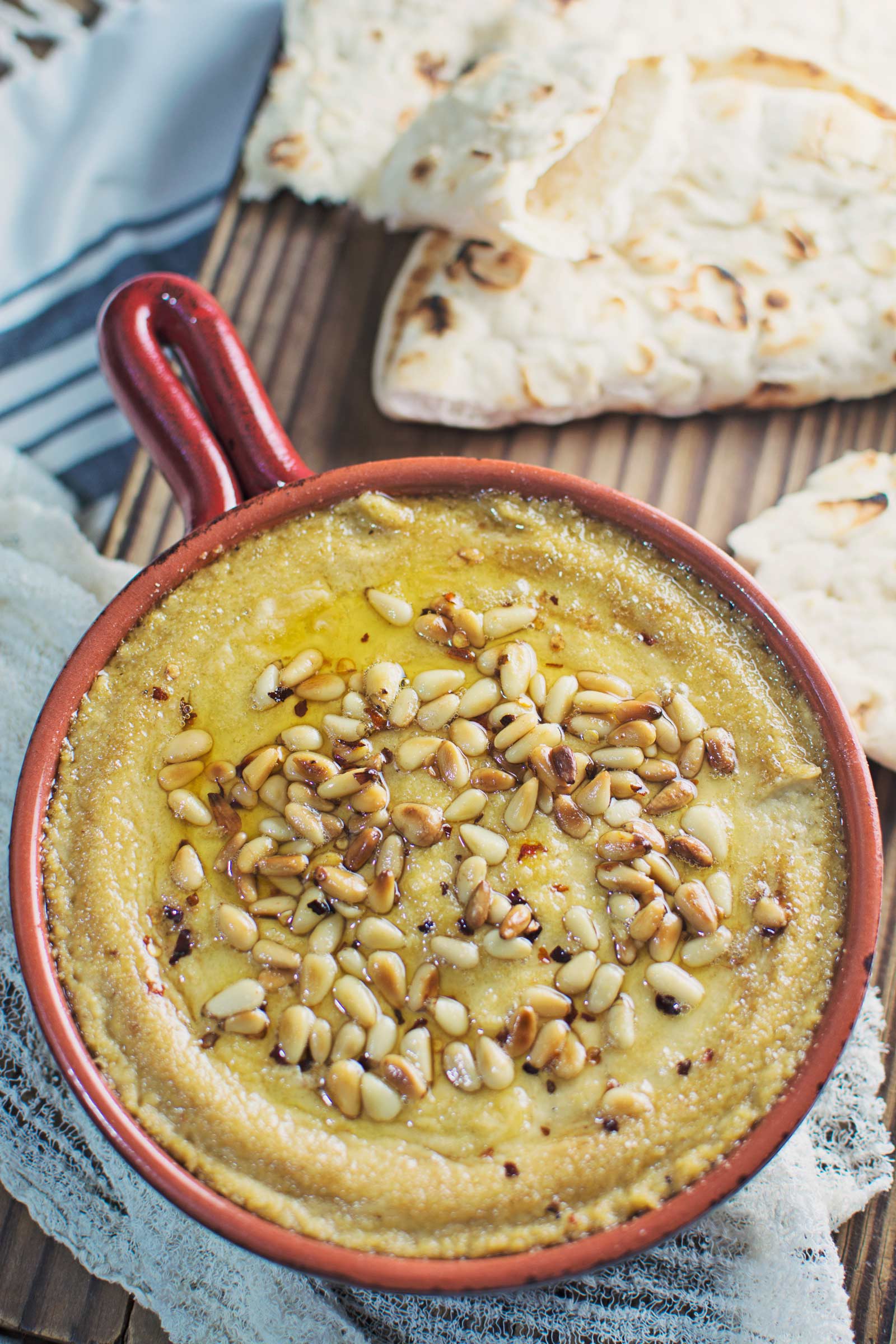 Try this Baked Hummus topped off with buttery, toasted pine nuts and served up with some pita bread! It's great for your next get together, or as a snack. Recipe @LittleFiggyFood