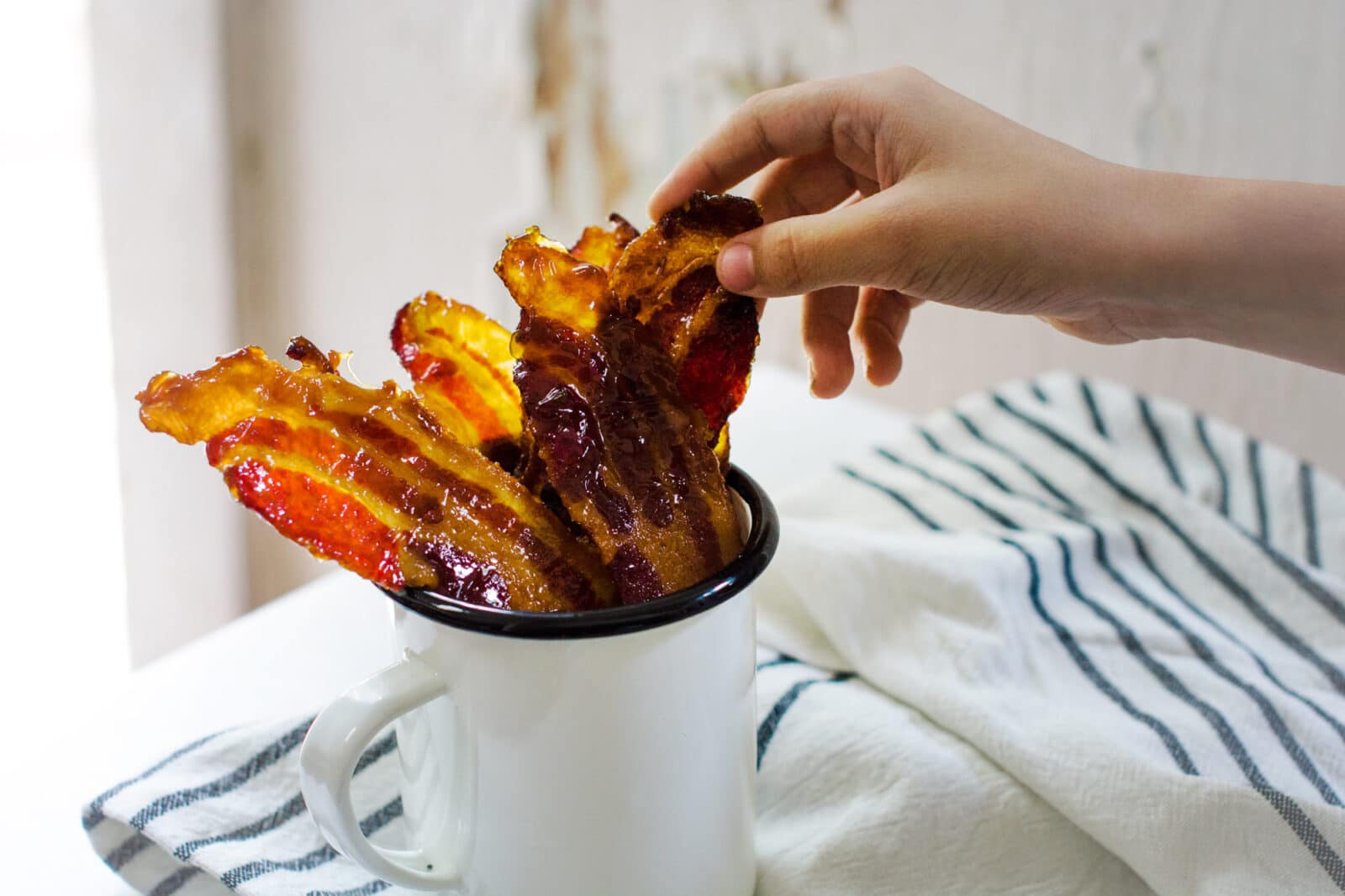 Enjoying candied bacon, an ideal tailgating recipe idea.