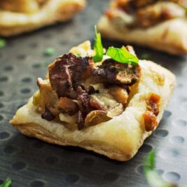 Mushroom puff pastry appetizers on baking tray.