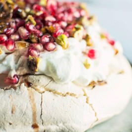 A gorgeous Winter Pavlova, with scattered pomegranate seeds, and topped off with pistachio brittle and plenty of cardamom scented cream! Recipe @LittleFiggyFood