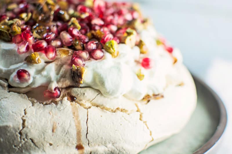 A gorgeous Winter Pavlova, with scattered pomegranate seeds, and topped off with pistachio brittle and plenty of cardamom scented cream! Recipe @LittleFiggyFood