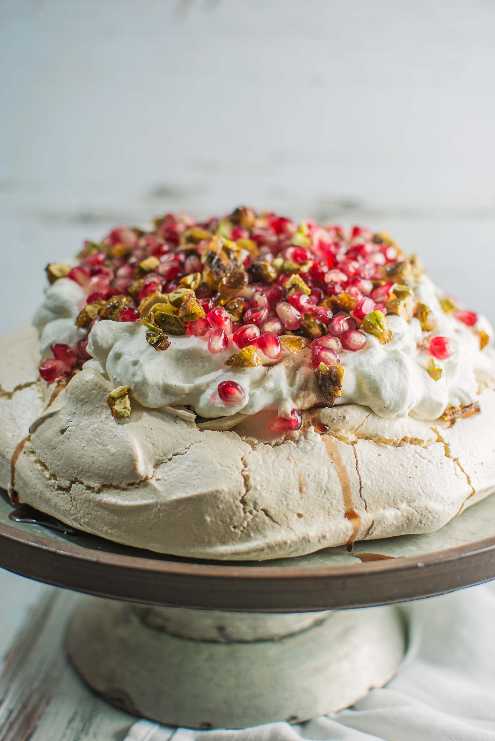 A gorgeous Winter Pavlova, with scattered pomegranate seeds, and topped off with pistachio brittle and plenty of cardamom scented cream! Recipe @LittleFiggyFood