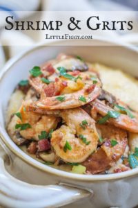 A bowl of Shrimp and Grits topped with sautéed shrimp, diced bacon, mushrooms, and chopped parsley, with the text Shrimp & Grits LittleFiggy.com at the top.