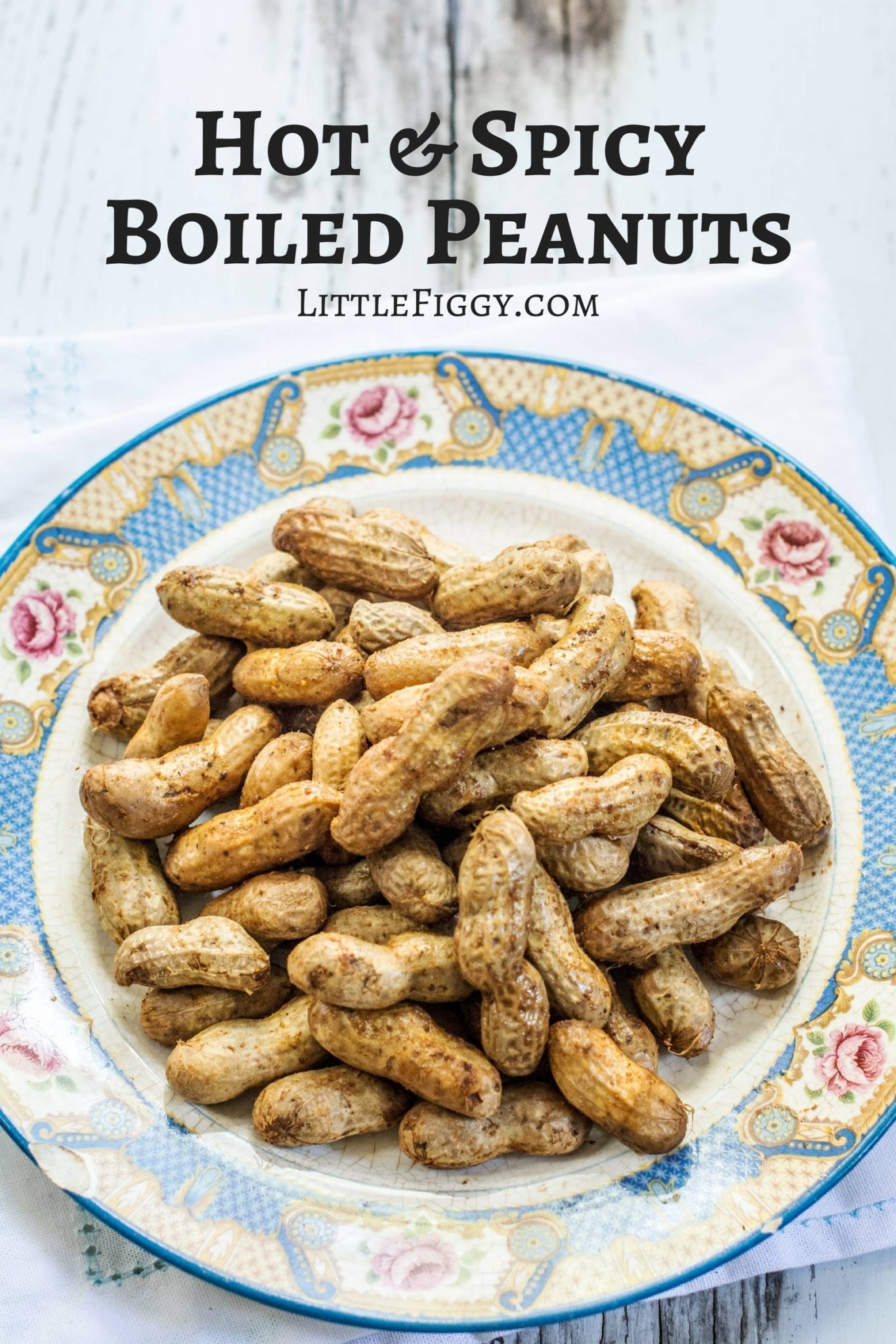 A plate of Boiled Peanuts in their shells is displayed on a decorative floral-patterned plate. Text above the plate reads Hot & Spicy Boiled Peanuts and LittleFiggy.com.
