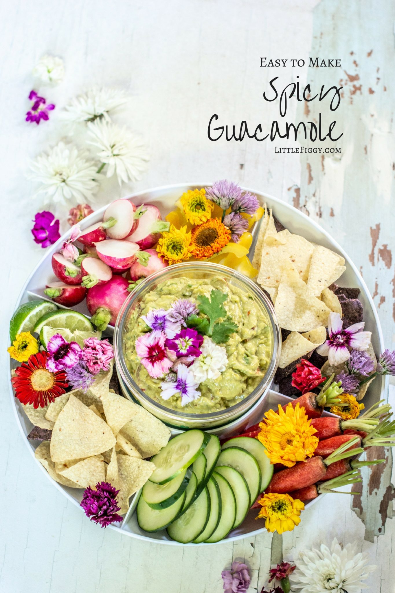 Serving dish with vegetables and spicy guacamole nested in middle of dish, decorated with pink and white flowers.