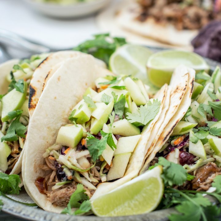 Carnitas BBQ pulled pork tacos with apple salsa and a lime slice