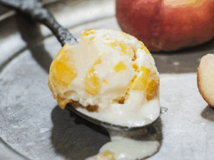 Peach ice cream scoop and fresh peach slices.