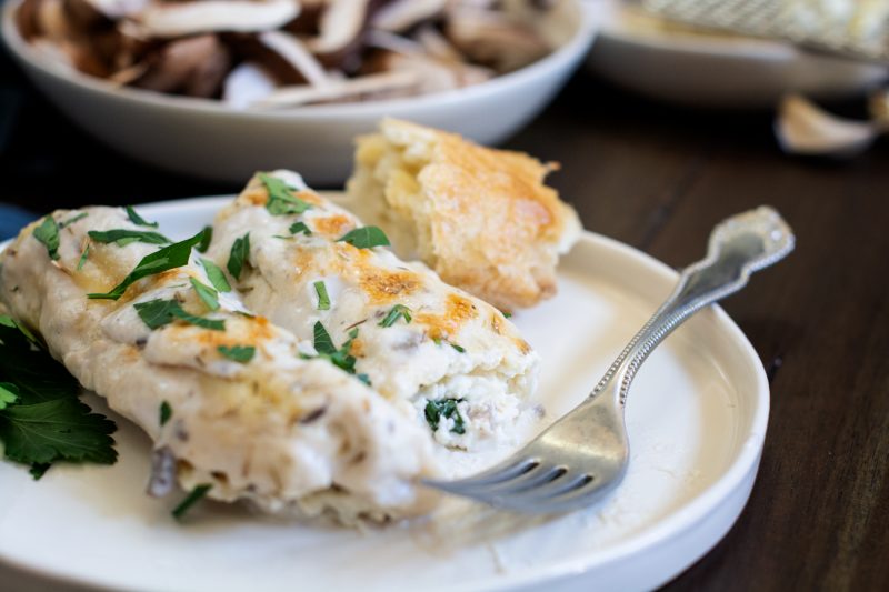 Hot Manicotti with ricotta and mushrooms on white plate