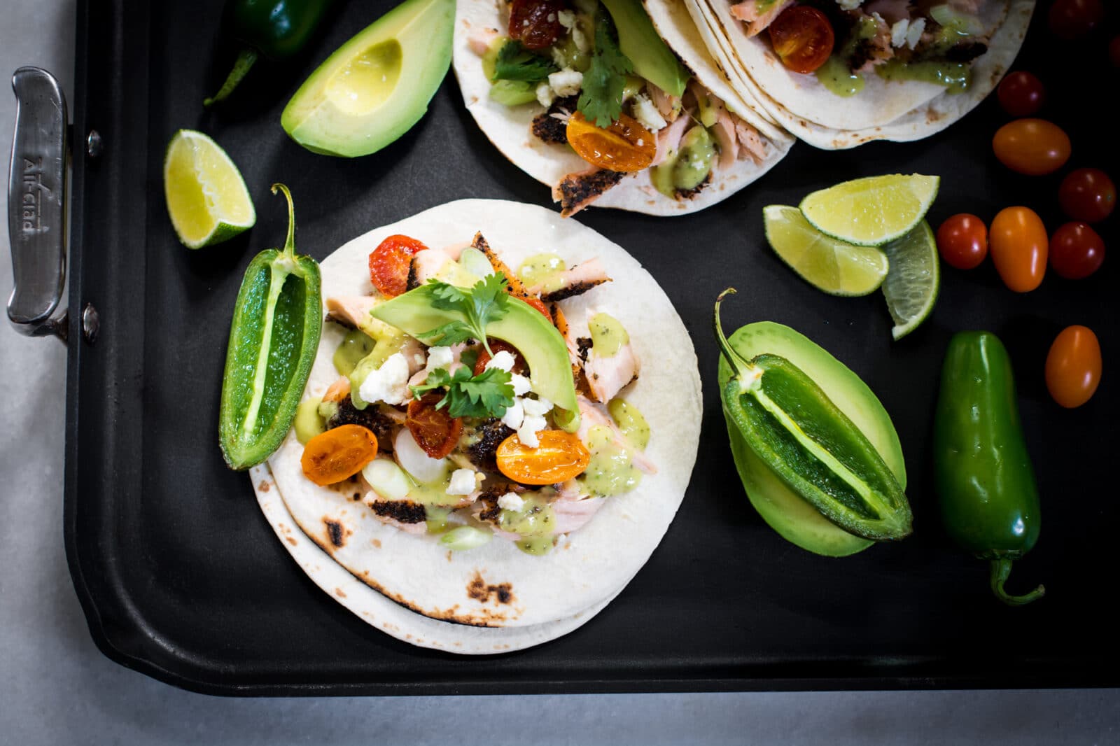 Fish tacos served with avocado, salsa, and jalapenos