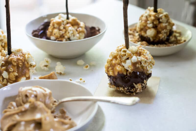 Peanut butter caramel popcorn balls on a stick