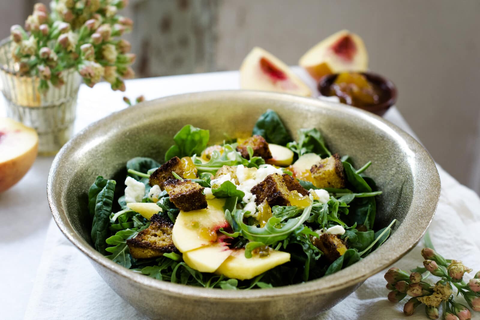 Serving a fresh bowl of farmers salad with fruit and croutons