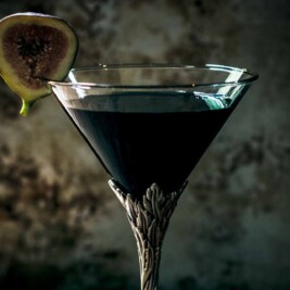 Elegant cocktail glass with fig garnish