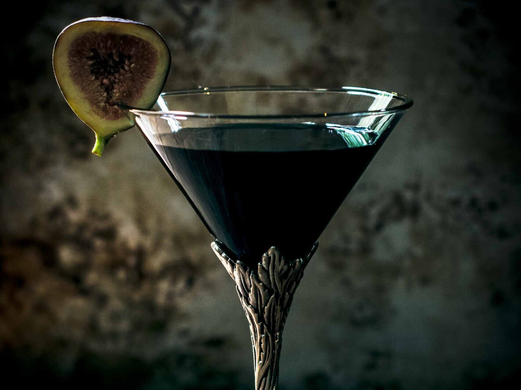 Elegant cocktail glass with fig garnish