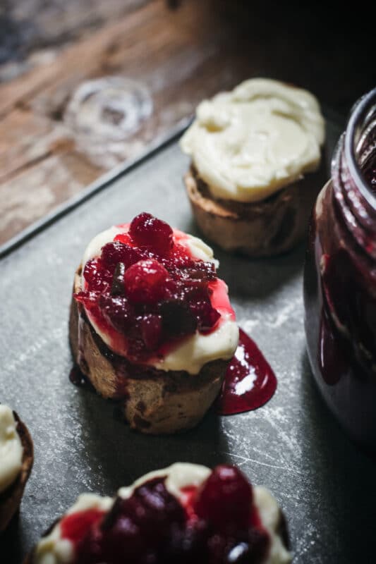 Drizzling cranberry jelly on toasted baguettes with brie