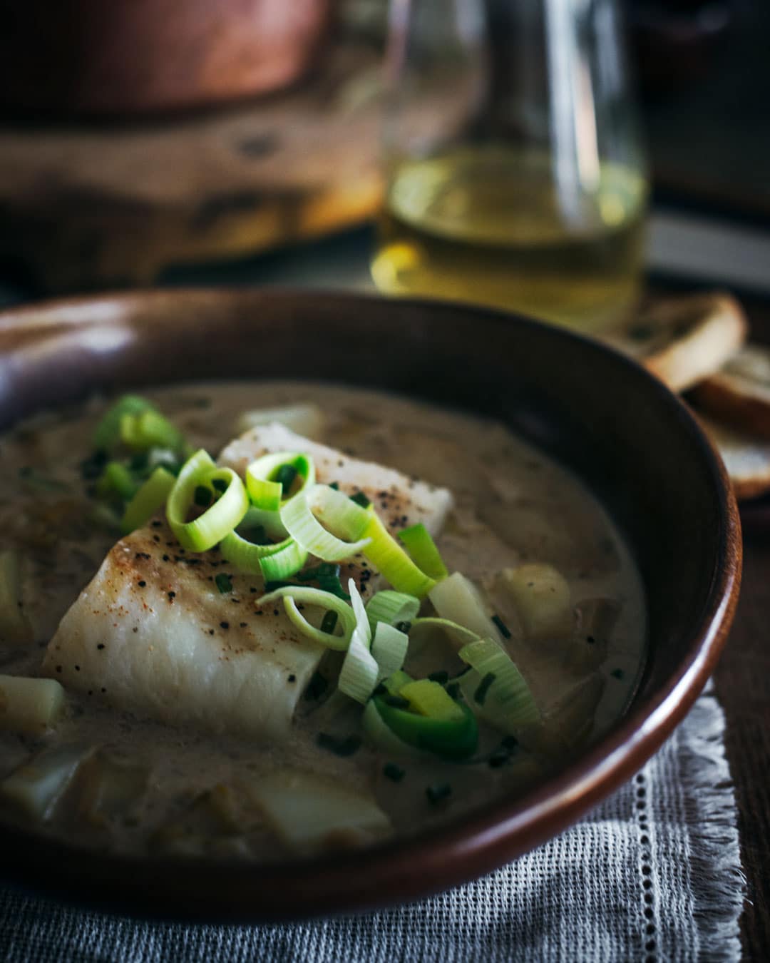 Baked cod with leek and potato soup in bowl