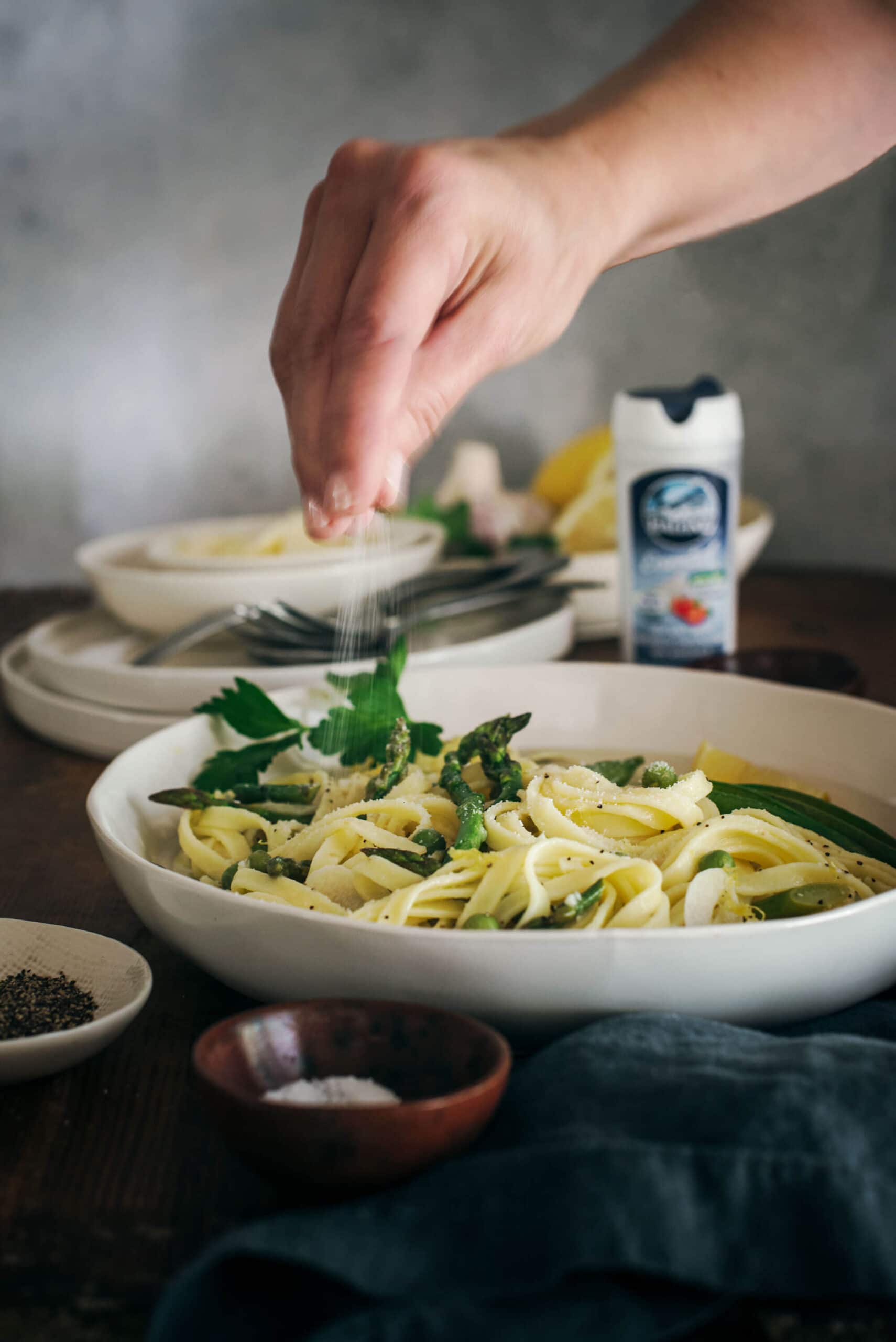 Sprinkling La Baleine Sea Salt on spring pasta dish.