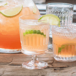 Refreshing citrus cocktails with lime garnish on table.