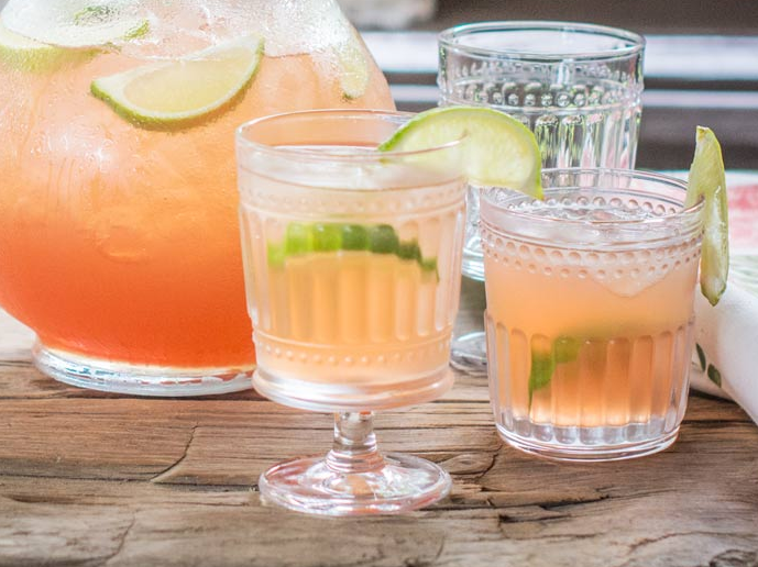 Refreshing citrus cocktails with lime garnish on table.