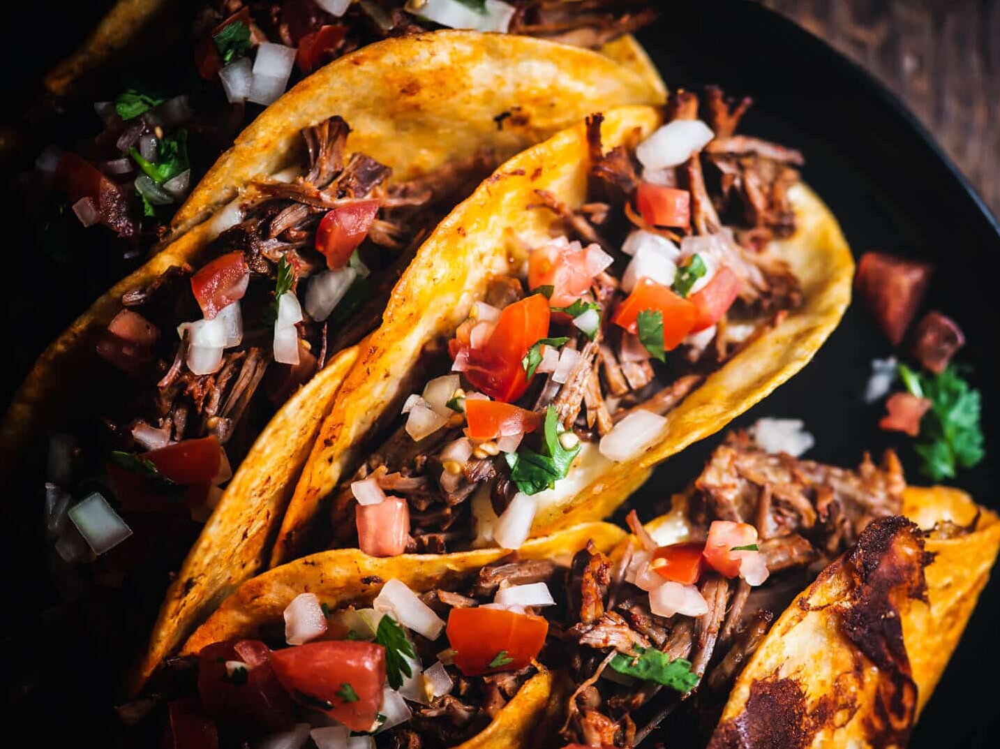 Delicious birria tacos with cilantro and onion.