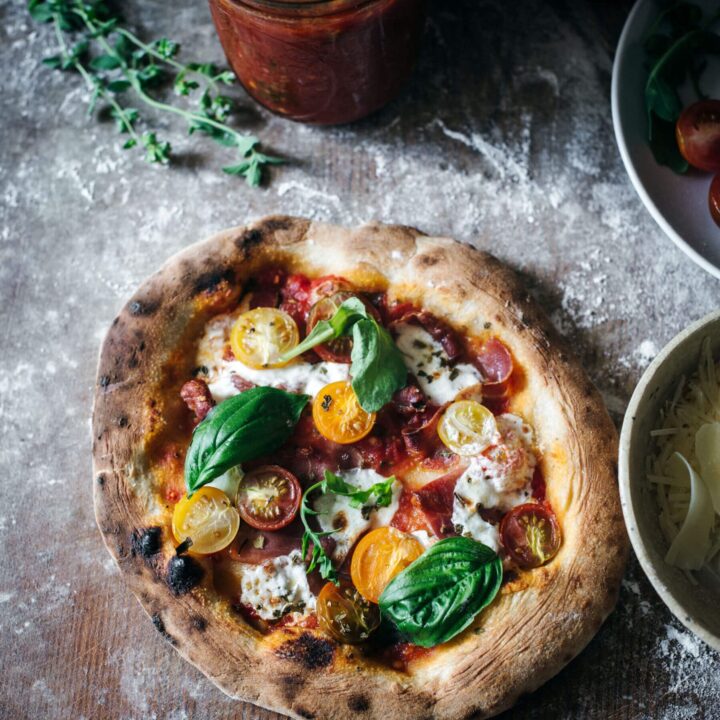 Calabrian pepper and prosciutto pizza ready to slice and serve