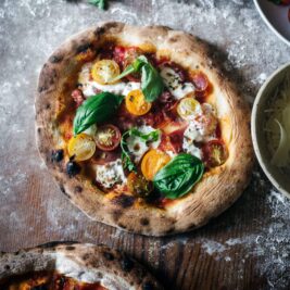Calabrian pepper and prosciutto pizza ready to slice and serve