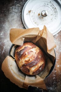 crusty dutch oven bread loaf on a cutting board