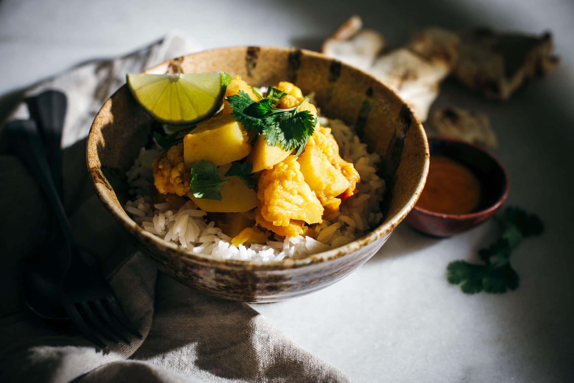 Brown bowl of rice and cauliflower butternut squash and potato curry