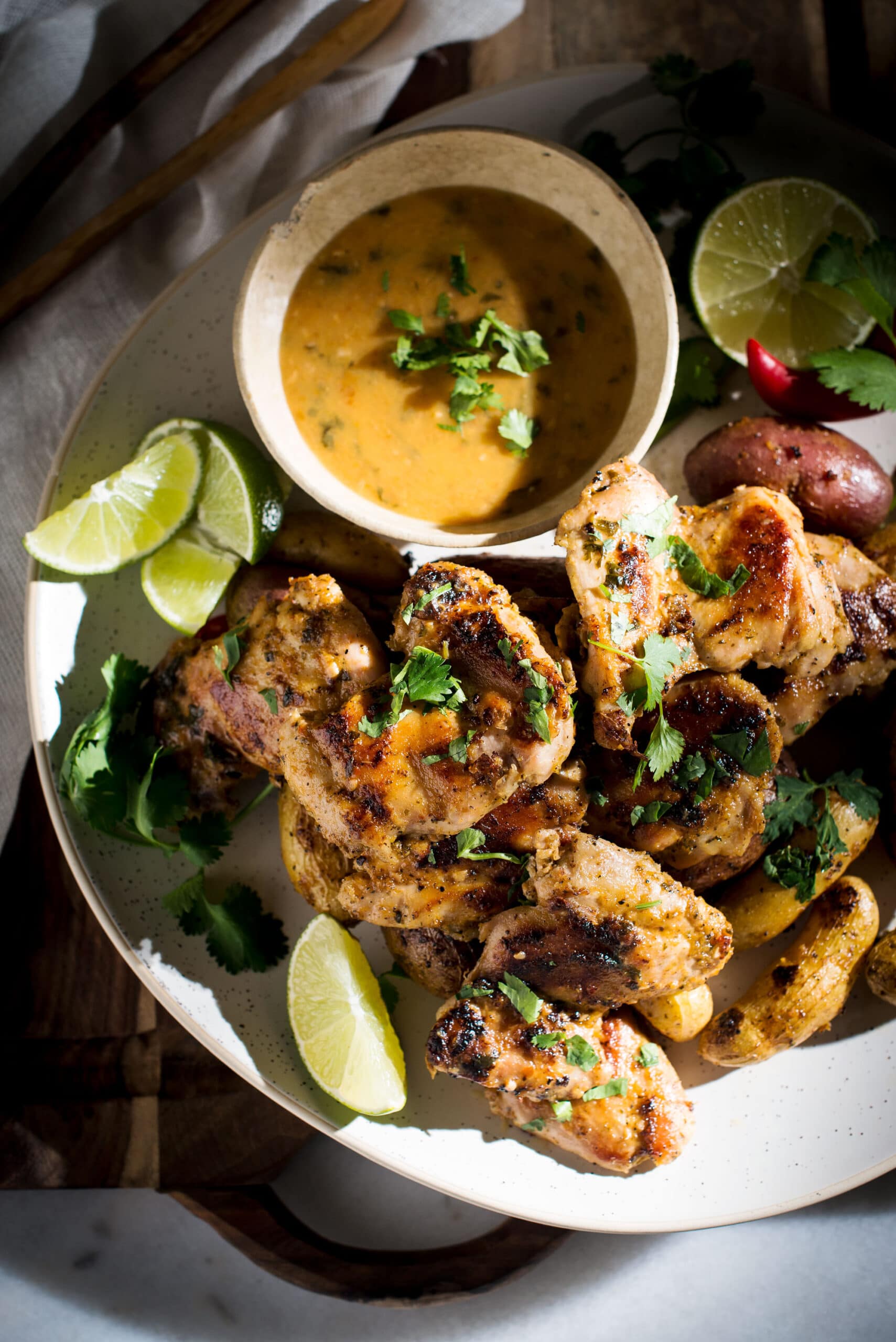 Spicy chicken with dipping sauce and lime wedges