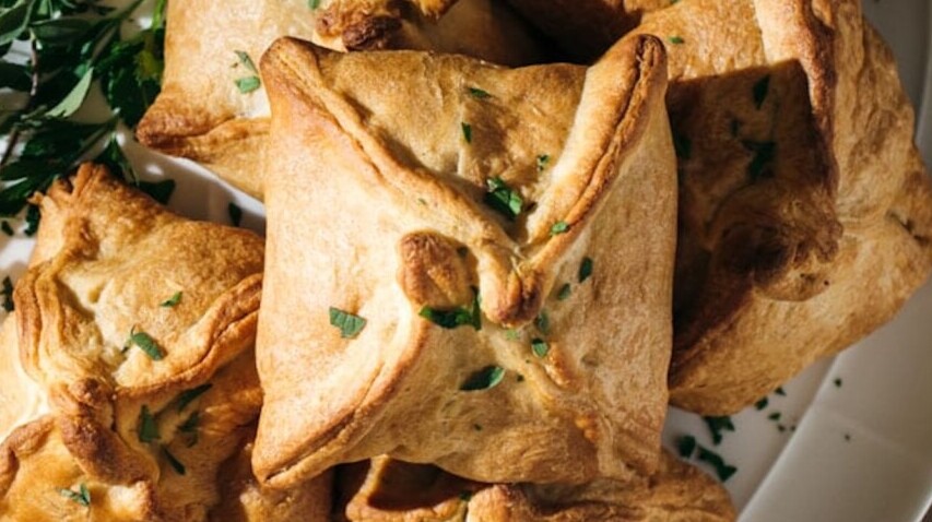 Baked pastries with herbs on wooden table
