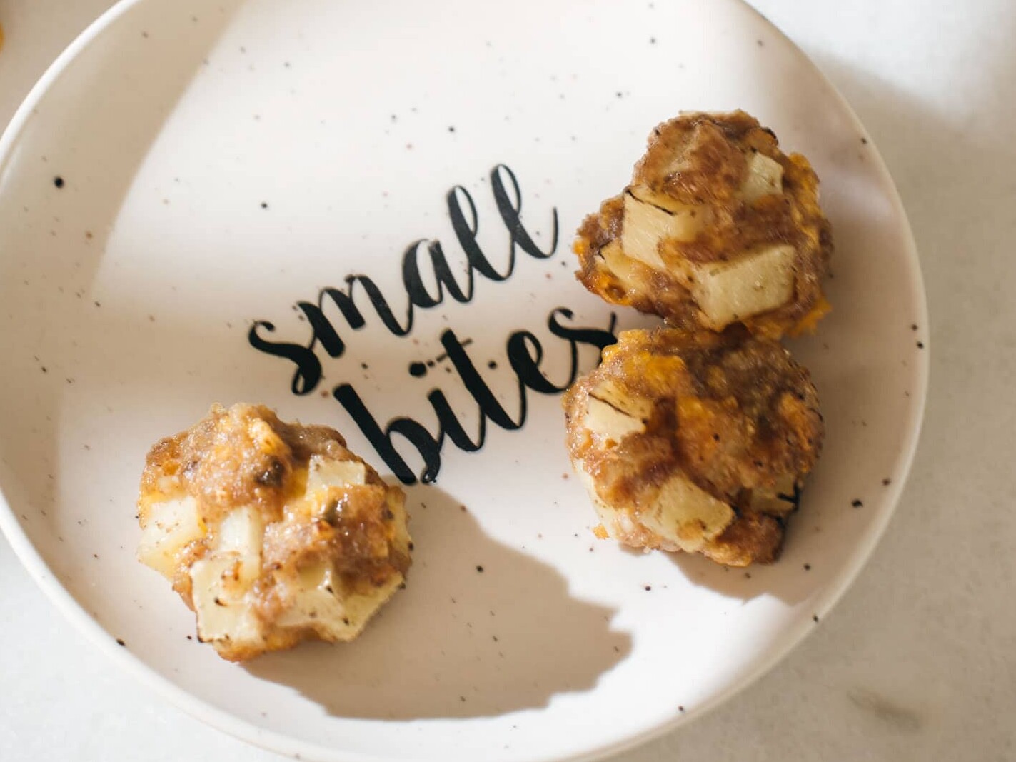 Small bites plate with savory snacks on marble surface.