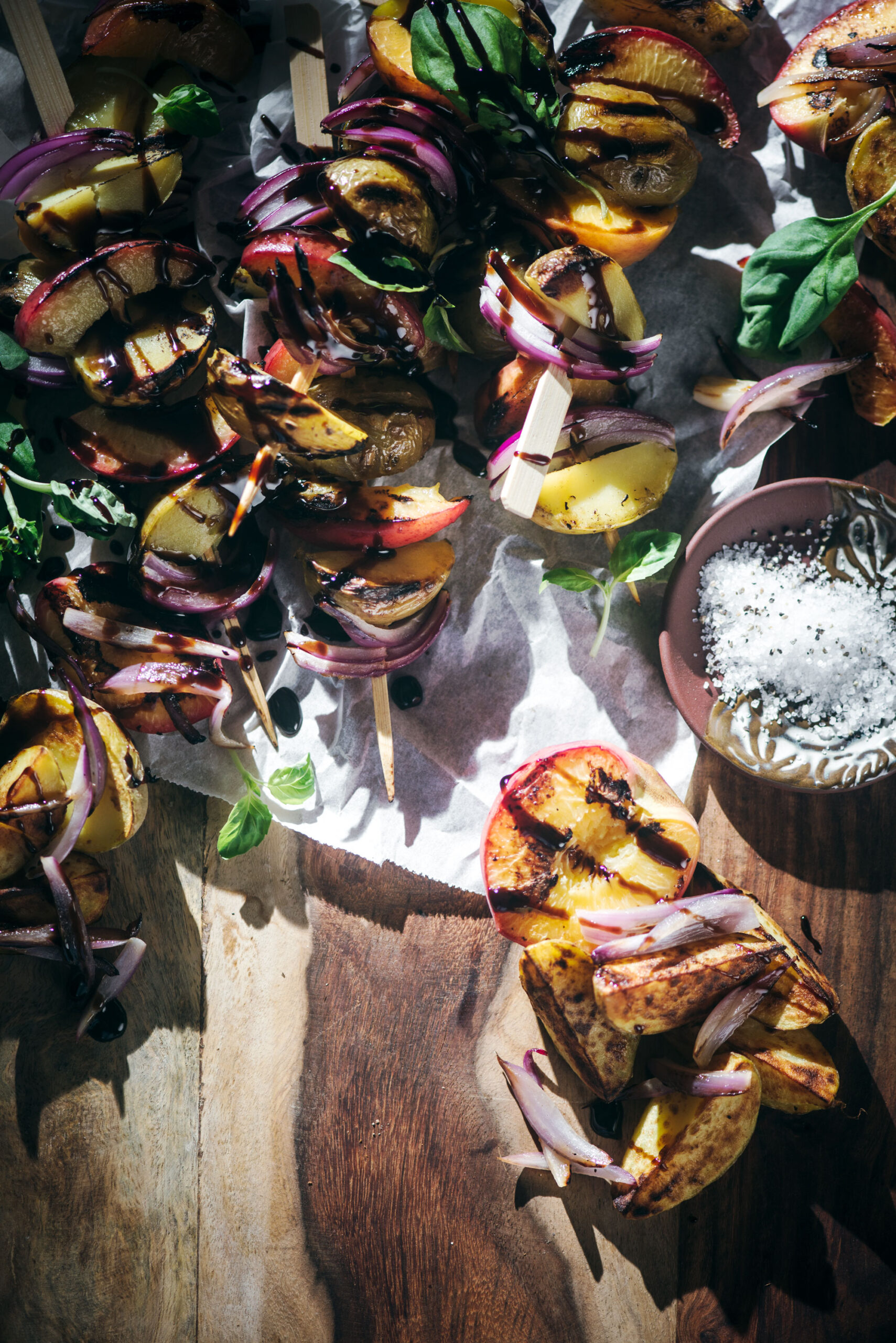 Grilled potato kabobs on wooden board - served on skewers or as salad