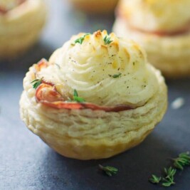 Savory puff pastry appetizers with herbs on slate.